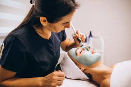 cosmetologist-applying-mask-face-client-beauty-salon-1-scaled